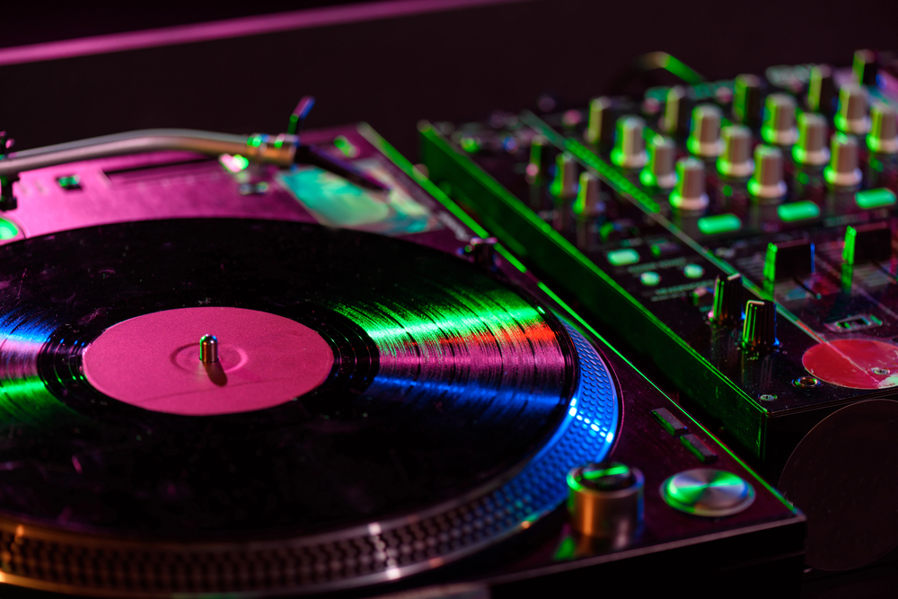 DJ-mengpaneel met feestende mensen op de achtergrond